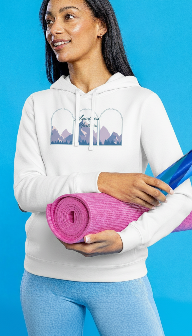 Woman holding a yoga mat and a blue water bottle wearing a Mountains over Martinis white hoodie against a blue background